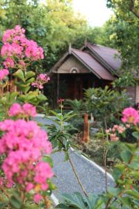 高兰兰达快乐山旅馆的一座花园,在一座建筑前方种有粉红色花卉