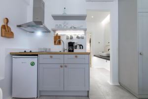 纳克索乔拉Arco Naxos Luxury Apartments的厨房配有白色橱柜和水槽