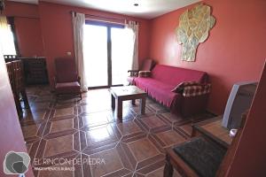 恩吉达诺斯El Rincon de Piedra的带沙发和红色墙壁的客厅
