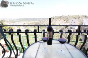 恩吉达诺斯El Rincon de Piedra的桌子上放有一瓶葡萄酒和两杯酒