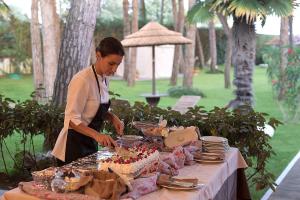 利多迪耶索罗Hotel Gallia & Resort的把蛋糕切在桌子上的一个女人