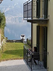 奥利维托拉里奥Residence Matilde的坐在阳台上的女人,看着水面
