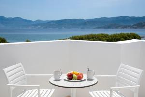 阿基欧斯尼古拉斯Naiades Marina Hotel的一张桌子,上面放着一盘水果和两把椅子