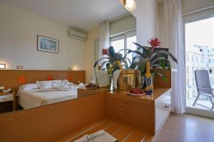 米兰马瑞提那里多尔菲酒店的一间卧室配有一张床和一张植物桌子