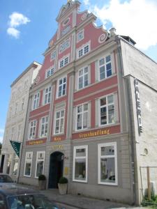 施特拉尔松德豪斯沃弗卡纳酒店的街道拐角处的一座红色大建筑