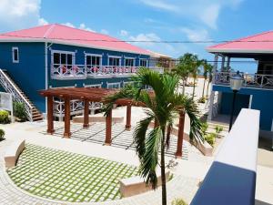 珀拉什奇亚Brisa Oceano Resort的蓝色的建筑,设有野餐桌和棕榈树