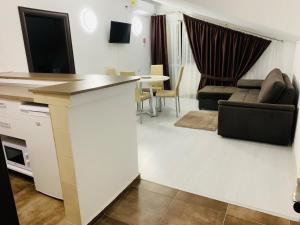 奥托佩尼FAST Airport Accomodation的厨房以及带沙发和桌子的客厅。