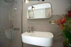 库卡里Eftopia Beachfront Studio的浴室设有白色水槽和镜子