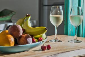 库卡里Eftopia Beachfront Studio的桌上一碗水果和两杯葡萄酒