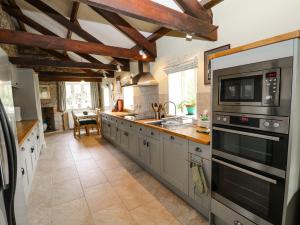 卡林顿The Groom's House的厨房配有不锈钢用具和木梁