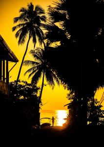 亭可马里Akki's Hostel的日落时在海滩上散步的人