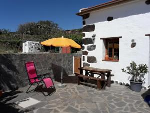 IsoraFinca La Ramona的庭院配有两把椅子、一张桌子和一把遮阳伞