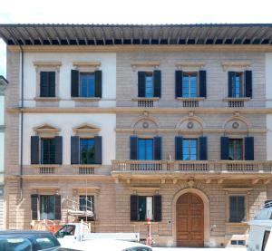 佛罗伦萨Giardino D'Azeglio Locazione Turistica的一座拥有许多窗户和木门的建筑