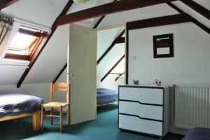 PleuvenSue's cottages的一间阁楼卧室,配有两张床和梳妆台
