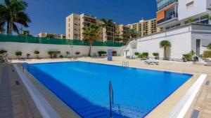 阿罗纳Apartamento con Vistas al Mar en Los Cristianos的一个大型蓝色游泳池,其建筑背景为: