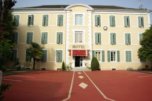 波城The Originals Boutique, Villa Montpensier, Pau (Inter-Hotel)的前面有一个红色停车场的酒店