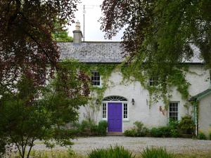 BallintogherThe Coachhouse @ Kingsfort House的白色的房子,有紫色的门