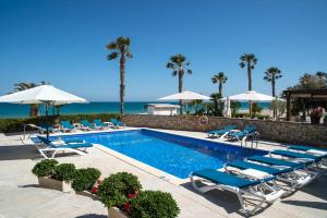 迈阿密普拉特亚Cala Cristal by Pierre & Vacances Premium的一个带躺椅的游泳池和海洋
