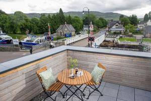 奥古斯都堡Lock Chambers, Caledonian Canal Centre的俯瞰河流的阳台配有桌椅