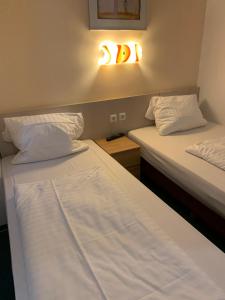 慕尼黑慕尼黑新贸易展览会议中心酒店的墙上有灯的房间里设有两张床