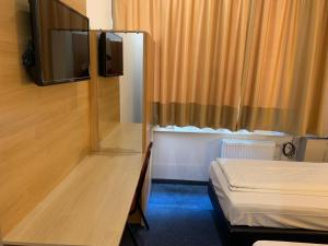 慕尼黑慕尼黑新贸易展览会议中心酒店的小房间设有床和电视