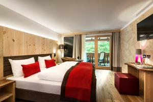 拉瓦莱珀斯塔佩蒂鲁亚酒店的酒店客房配有一张带红色枕头的大床