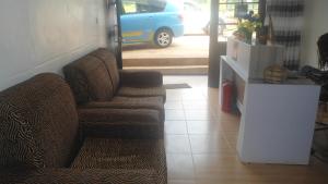 基加利AIRPORT INN MOTEL的带沙发和蓝色面包车的客厅