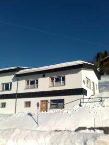 拉特恩斯Berg & Skihütte -Schmittenhof的前面有雪的白色房子