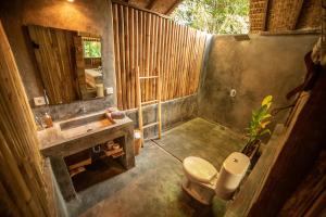 吉利阿尔Musa Villas and Bungalows Gili Air的一间带水槽、卫生间和镜子的浴室