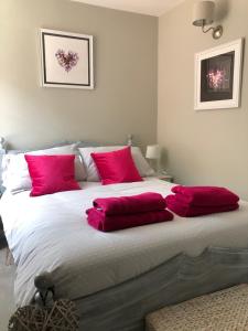 基督城Boutique Townhouse in Christchurch Dorset的一间卧室配有一张带红色枕头的大床
