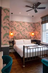 斯坦福德王冠酒店的一间卧室配有一张带热带壁纸的床