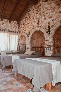 ColungoAntiguo Rincón的砖墙内带三张床的房间