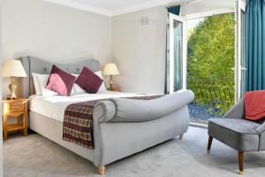 塔洛沃尔斯利山酒店&高尔夫度假胜地的卧室配有床、椅子和窗户。