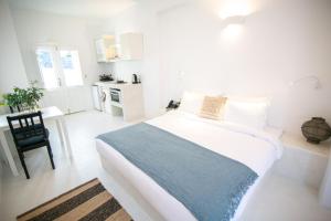 伊亚Apanomeria Boutique Residence的白色卧室配有一张大床和一张书桌