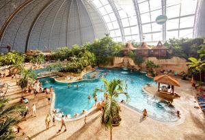 克劳斯尼克Tropical Islands Campingplatz的主题公园里有一个大型游泳池,里面的人