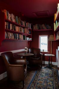 TilstonThe Carden Arms的图书馆配有两把椅子、一张桌子和书籍