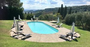 巴尔贝里诺瓦尔德尔萨Farmhouse B&B Il Paretaio的一个带草坪椅和遮阳伞的游泳池