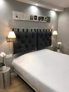 多维尔HSH Marina-Deauville Superbe Appartement的一间卧室配有一张大床和黑色床头板