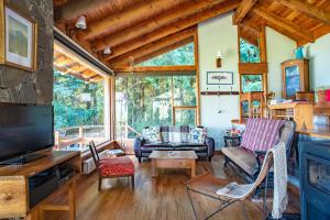 拉安戈斯图拉镇科利纳德尔曼萨诺山林小屋的客厅配有家具和大窗户。