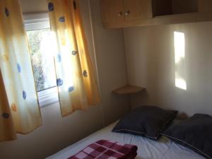圣皮索内维尔camping Manex的一间小卧室,配有床和窗户