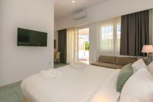 蒂锡利维蒂锡利维海滩拉肯诗酒店的卧室配有一张白色的大床和一张沙发。