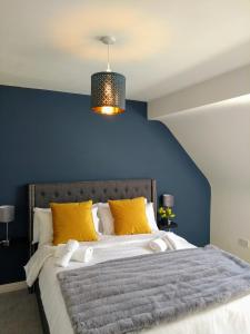 克利夫登Rosies的一张带黄色枕头和蓝色墙壁的床