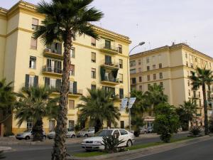 马拉加Apartamento Malagueta 1 Linea playa centro Malaga的街道前方有棕榈树的建筑