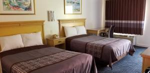 纽波特纽斯Budget Lodge的酒店客房配有两张床和一张书桌