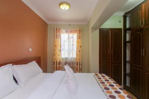 内罗毕Zarita Boutique Hotel的卧室配有白色的床和窗户。