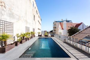 埃斯托利尔Chalet Estoril Luxury Apartments的建筑物一侧的游泳池
