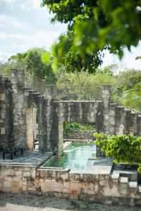 科巴Coqui Coqui Papholchac Coba Residence & Spa的一座古老的石头建筑,设有游泳池