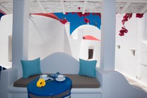 米克诺斯城Eleanna's Mykonos的配有白色墙壁和蓝色枕头的桌子