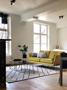 根特Bed & Boon的客厅配有黄色沙发和地毯。