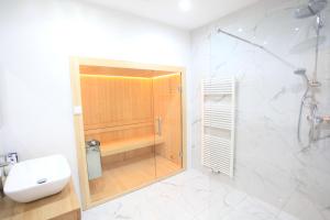 莱比锡Zollikof Aparts - Sauna & Studioapartments的带淋浴、卫生间和盥洗盆的浴室